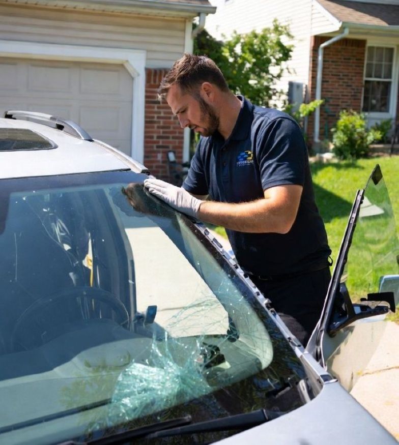 auto glass technician replacing a windshield in a residential driveway